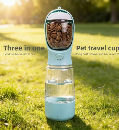 Light blue pet travel cup with clear lower chamber filled with brown kibble on grass | PicSEO 1786063205830